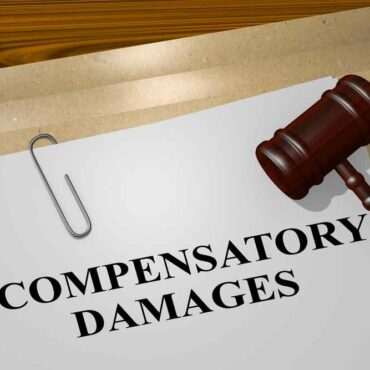 Gavel on top of file with the words compensatory damages
